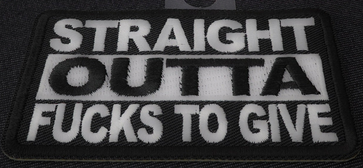 White fabric patch with bold black text reading "Straight Outta Fucks To Give" from THE CHEAP PLACE, 4x1.5 inches in size.
