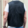Milwaukee Leather men's black leather motorcycle vest with side laces, shown from the back in a lifestyle setting.